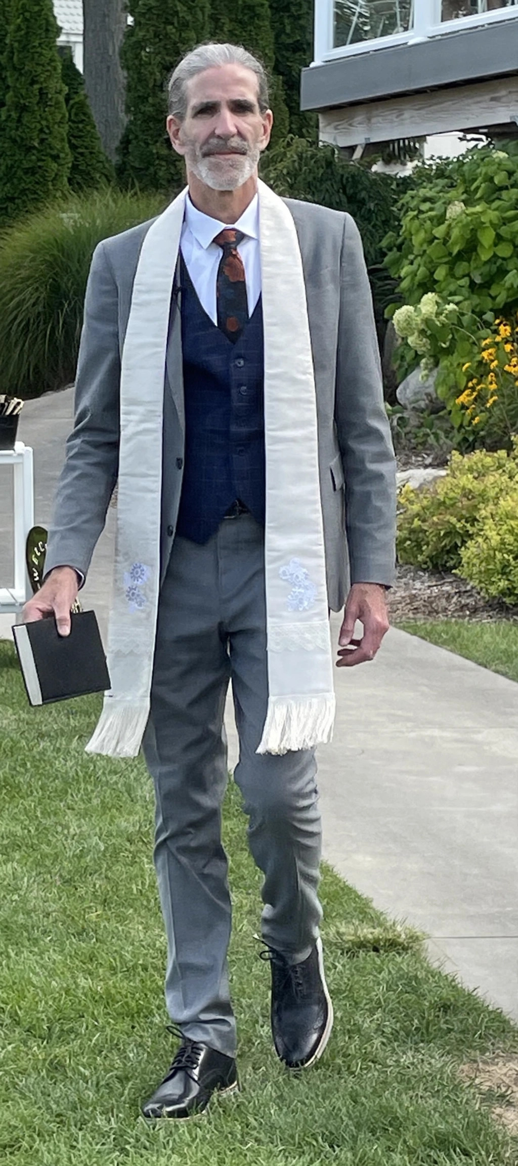 Ordained minister Randy Johncox in ceremonial vestments holding a black book